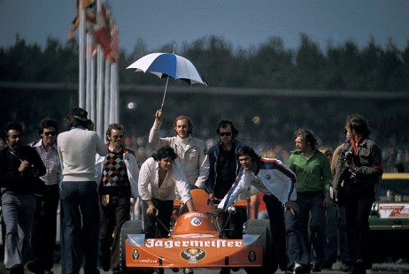 Grid positions are taken before the Jim Clark Revival race Hockenheim 1974, Formula 2 European Championship, with Hans-Joachim Stuck's holding an umbrella above his March 742
